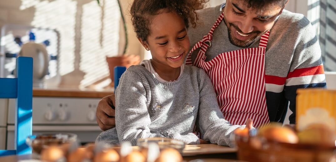 Un padre y su hija preparando una receta en la cocina