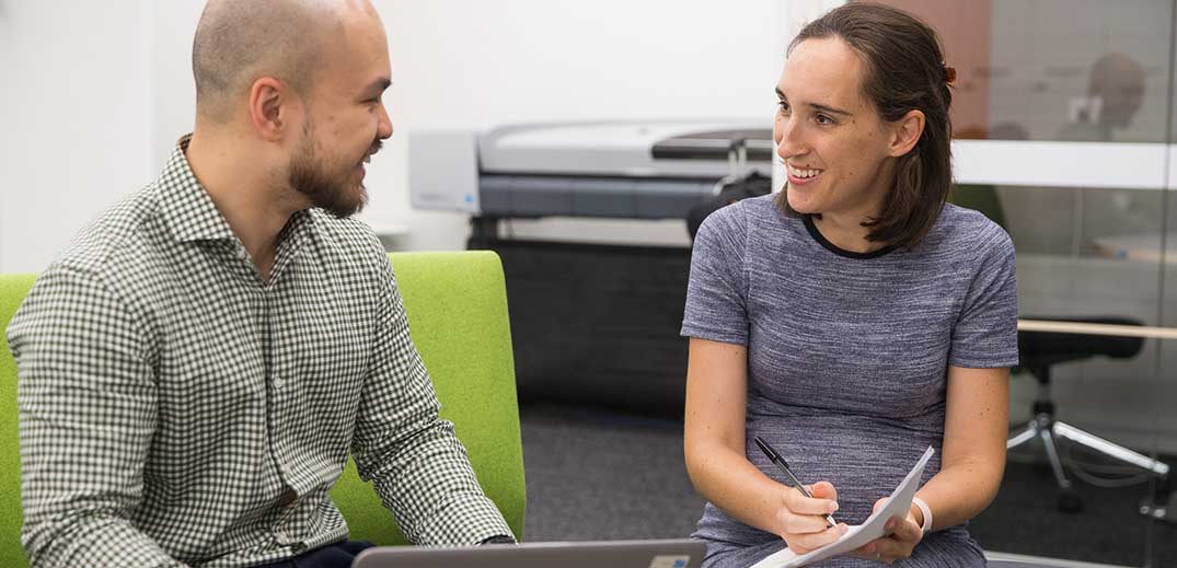 man-woman-office-discussion-wide