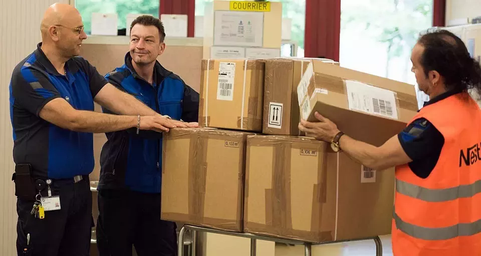 Tres hombres embarcan cajas